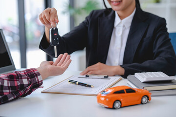Insurance officers hand over the car keys after the tenant. have signed an auto insurance document or a lease or agreement document Buying or selling a new or used car with a car