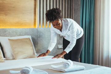 African maid making bed in hotel room. Staff Maid Making Bed. African housekeeper making bed. Maid...