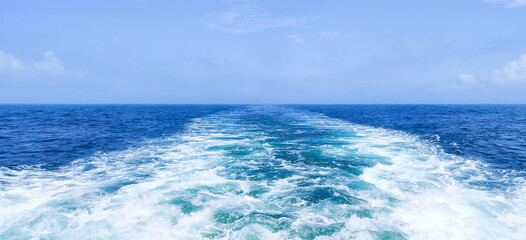 Trail on water surface behind of fast moving or sailing ship or boat