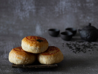 Tau Sar Piah (Savory Mung Bean Paste Biscuit) on rustic background with Chinese Tea Set with copy...