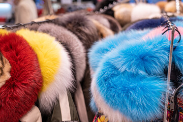Fur coats in a row on a hanger in the store. Female fashion, natural mink fur clothes of different...