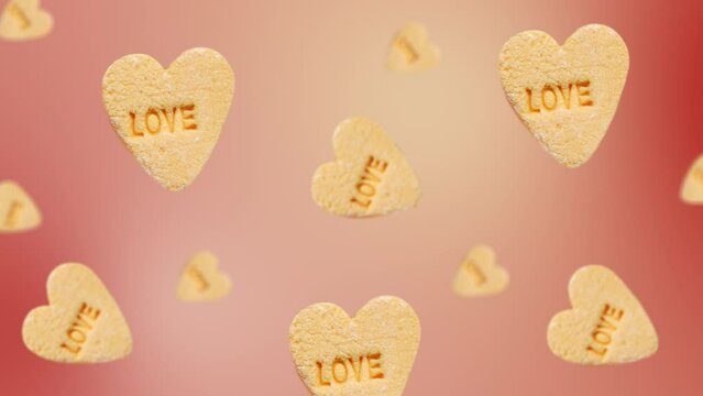 Flying and wiggle of different diameters heart-shaped yellow candies with label "Love"  on trending red color gradient background. Romantic Love concept for mother's, St. Valentine's and women's day.