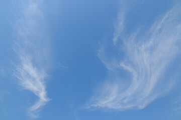 Thin white clouds on a blue background