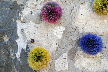 colorful fluffy balls decoration on the old stone wall