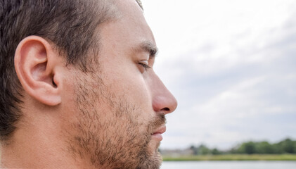 Obraz premium Face profile of a bearded man. unshaven face Beard on the face of a young man.