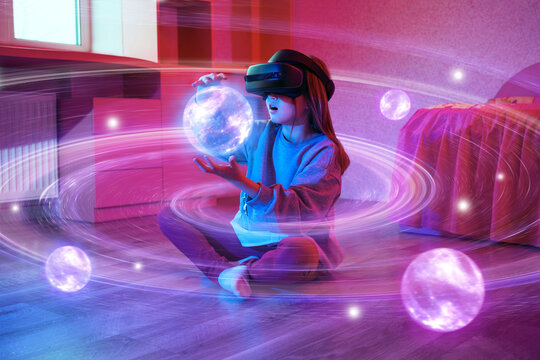 Child girl wearing virtual reality headset and looking at digital space system with planets or Universes. Space exploration with augmented reality glasses. 