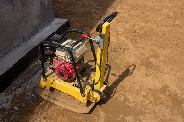 Vibratory plate heavy machine compactor for construction. Sand tamping at a construction site - obrazy, fototapety, plakaty