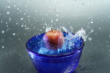 Apfel fällt in Wasserschüssel 
