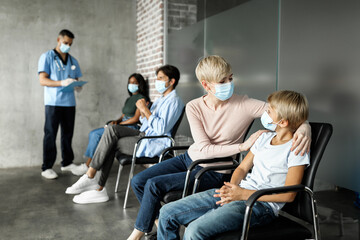 Mother comforting her teen child, getting vaccinated against COVID-19