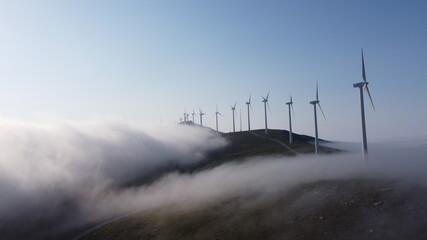eolic generators spining over the mist in the mountains
