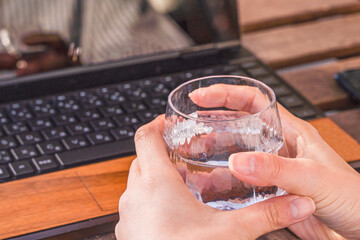 ビジネス用　在宅ワークをしながらお水を飲む女性