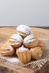 A pile of mini churros stuffed with dulce de leche and covered with sugar. Selective focus.