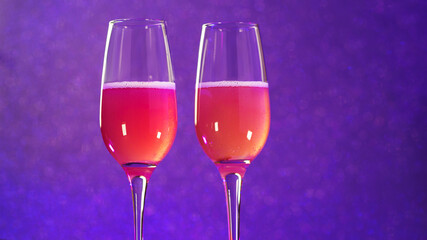 Two glasses of cold cider or champagne, neon background. A Valentine's day card