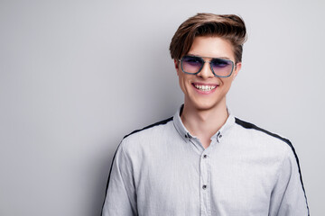 Men's accessories, optics. Handsome smiling man in shirt and modern sunglasses. Studio portrait