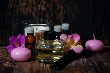 attributes of spa treatments - candles, aroma diffuser, rattan sticks and aroma oils on wooden...