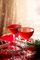 two glasses of red wine on the festive table on the background of a light curtain