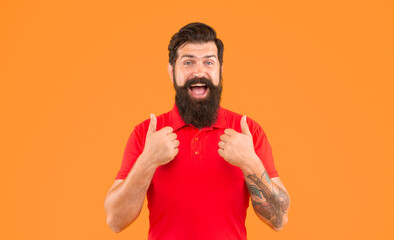 happy guy with beard and hairstyle showing thumb up on yellow background, skin care