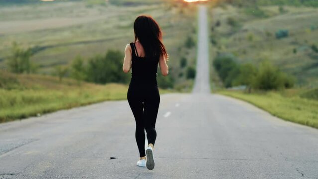 Sport running. Young fitness woman running on road at sunset. Concept healthy lifestyle.