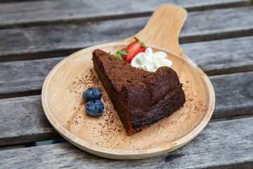Chocolate cake on the wooden plate.
