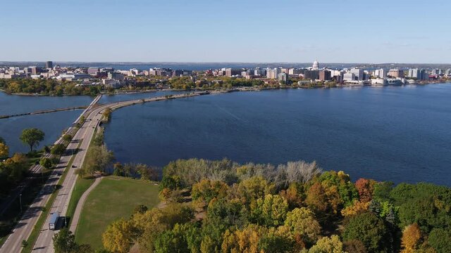 Flying Over John Nolen Drive towards Downtown Madison, Wisconsin Surrounded by Fall Colors (Drone - Pull Back to See Olin Park)
