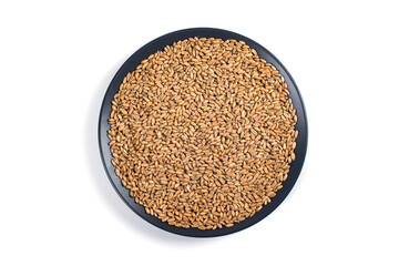 Wheat grains in a plate on a white background.