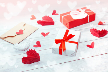 gift boxes and red hearts with a kraft envelope on a wooden background. High quality photo