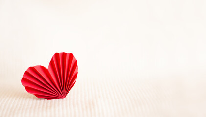 red paper corrugated heart on a warm knitted background. Copyspace. High quality photo