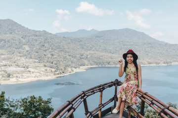 Fototapeta na wymiar Young pretty Asian woman feeling relax with ocean and mountain view in Wanagiri, Bali. Tourist concept.