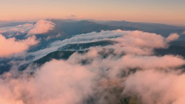 Ukraine, Carpathians, rocky peaks Gorgan - Khomyak and Synyak among wild coniferous and deciduous forests, captured aerially by a drone. After the rain in the valleys, fog and haze.  copter aerial vid
