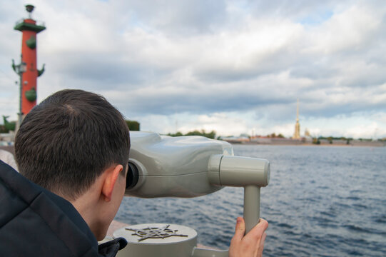 Guy looks in binoscope on city.