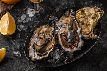 Fresh oysters close-up on ice served with lemon and wine.