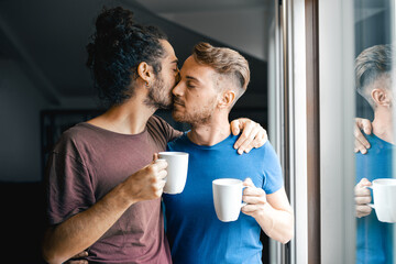 Couple of gay men drinking coffee at home, morning ritual of same sex lovers, gay pride and...