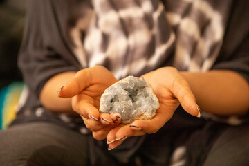 Close-up of woman's hands holding healing crystal