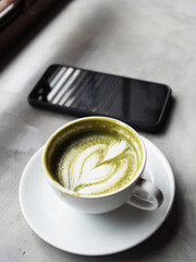 hot green tea and smartphone next to windown relaxing and rest time