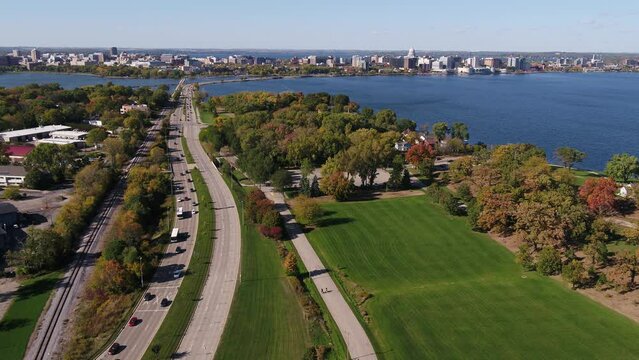 In Olin Park Flying Over John Nolen Drive towards Downtown Madison, Wisconsin Surrounded by Fall Colors (Drone - Push In)