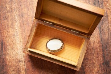 biała broszka drewniany pudełku na drewnianym stole