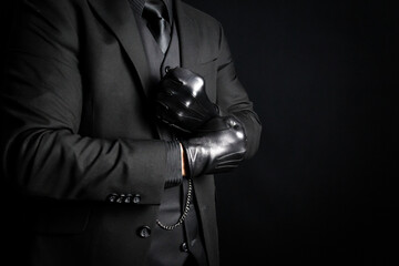 Portrait of Strong Man in Dark Suit Pulling on Black Leather Gloves. Mafia Hit Man or Criminal Gangster. - obrazy, fototapety, plakaty