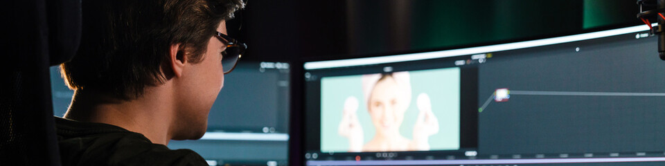 Back view of a young white man video editor