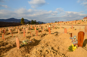 Graves in cemetery. Graveyard. Freshly-dug graves in a rows. Rising number of dead after the coronavirus disease. COVID-19 outbreak. Recently buried people.