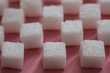 Sugar cubes on pink background