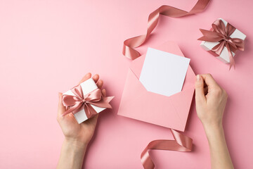 First person top view photo of valentine's day decor female hands holding pink envelope with card...