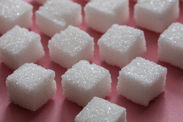 Sugar cubes on pink background