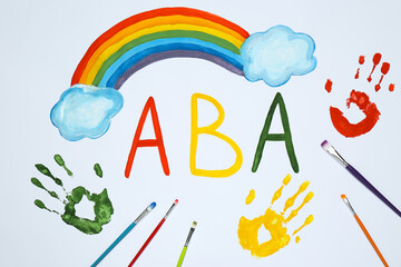 Drawn abbreviation ABA (Applied behavior analysis), rainbow, palm prints and paintbrushes on white...
