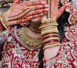 Beautiful Indian bride hands henna design hand jewelry kalira and red nail paint.