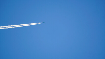 White smoke behind the plane in the sky