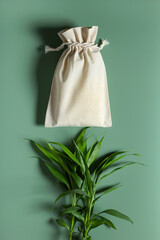 Cotton reusable bag bamboo on green background. Eco-friendly zero waste eco shopping.