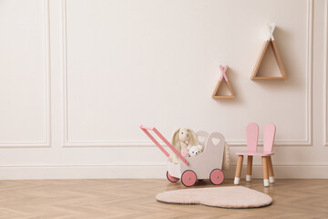 Child's toys, chair and wigwam shaped shelves on white wall indoors. Interior design © New Africa
