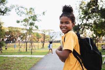 Africa American boy holding tablet computer for learning at park. He comes home from school with a happy smile. Learn Beyond Classroom © krumanop