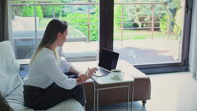 beautiful girl on the couch working on a laptop