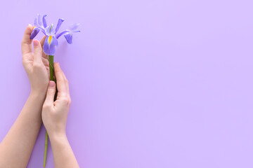 Obraz na płótnie Canvas Female hands with iris flower on color background